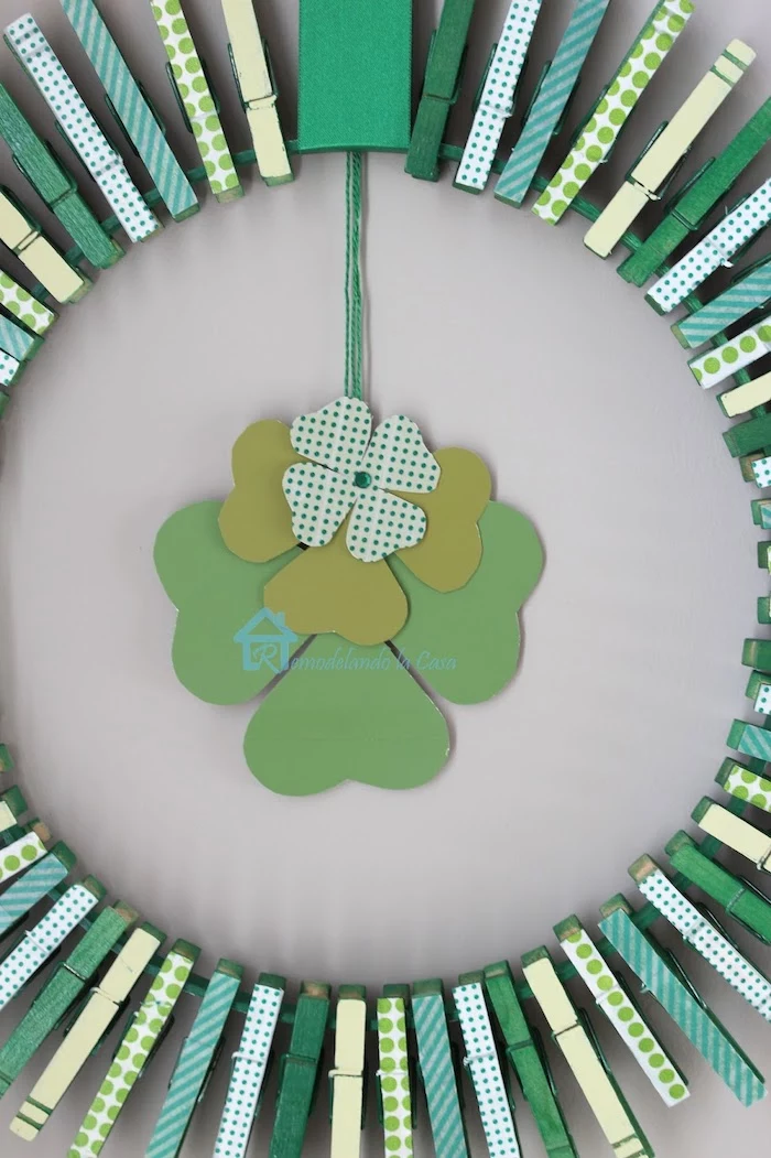 wreath made with clothespins, covered with washi tape with different patterns, st paddy's day, hanging on white wall