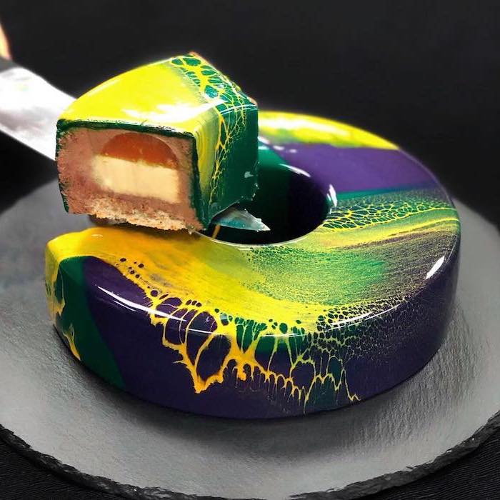 purple green and yellow marble glaze, one tier donut cake, slice taken out of it, how to make mirror glaze