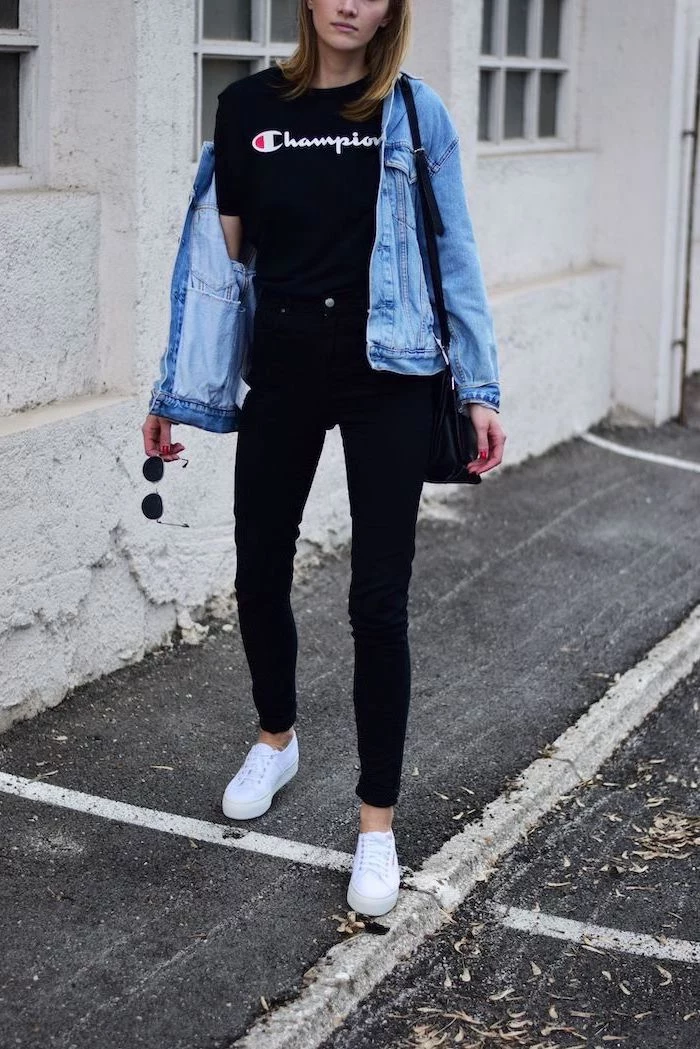  cute outfits for school, woman wearing all black outfit, black champion t shirt and jeans, denim jacket and white sneakers