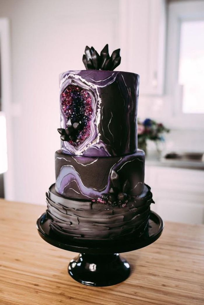 three tier cake, covered in black and purple marble fondant, decorated with black and pink rock candy, geode cake