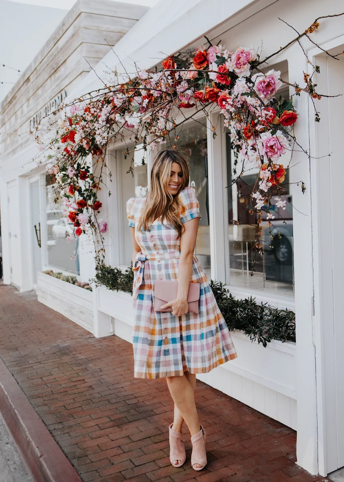 easter dresses for girls, blonde woman wearing a dress with colorful print, nude heels, standing underneath floral wreath