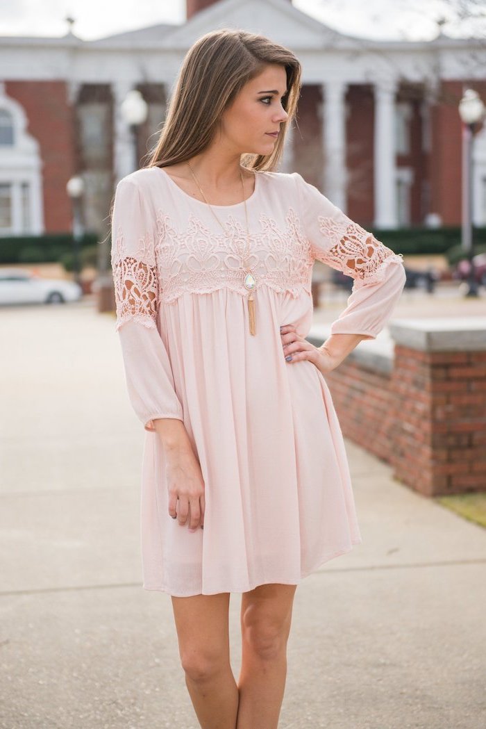 blonde woman standing on a sidewalk, easter dresses for girls, wearing a blush pink dress with lace