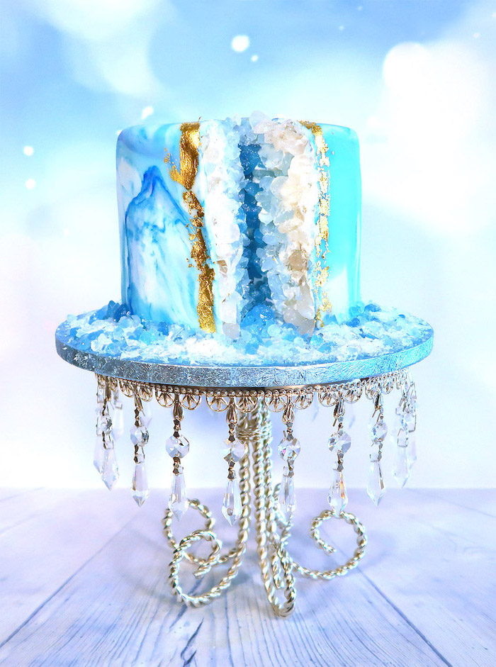 one tier cake, covered with blue and white marble fondant, decorated with rock candy, painted in blue and white, geo cake