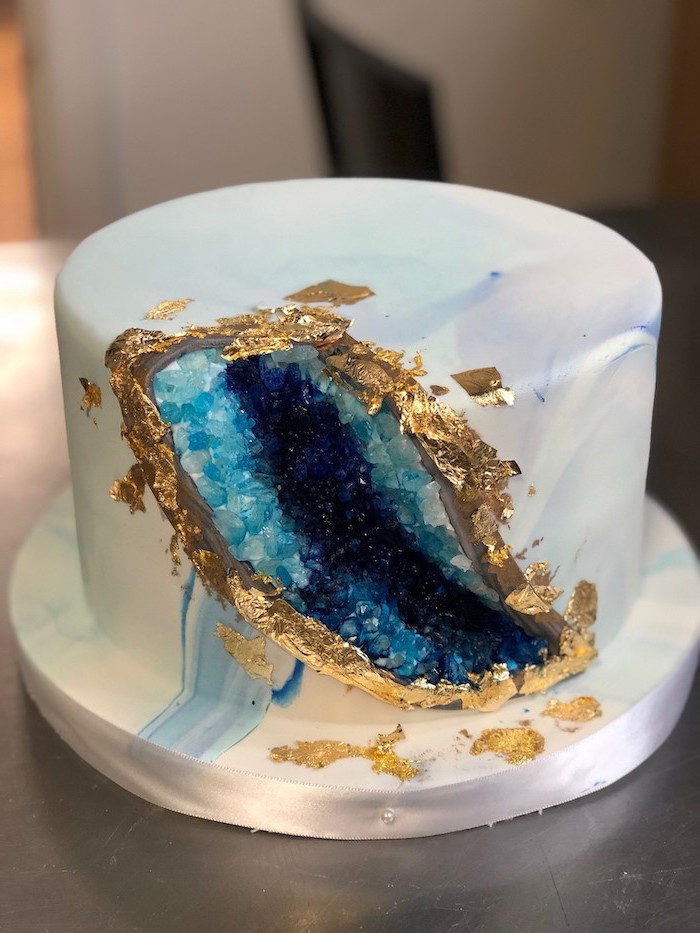 dark blue and turquoise rock candy decoration, gold edible leaves on the side, crystal cake, one tier cake with white fondant