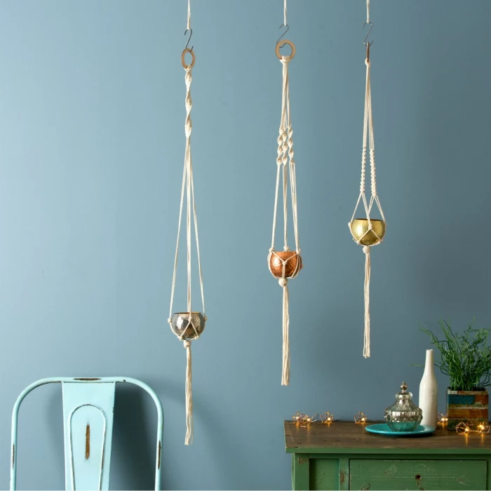 three small pots hanging from the ceiling, how to make a hanging planter, blue metal chair and blue wall in the background