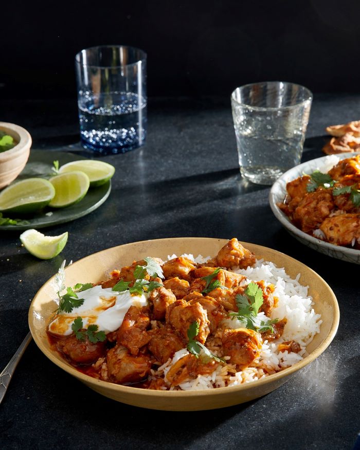 bowl of rice with creamy meat, placed on black surface, easter dinner recipes, water glasses on the side