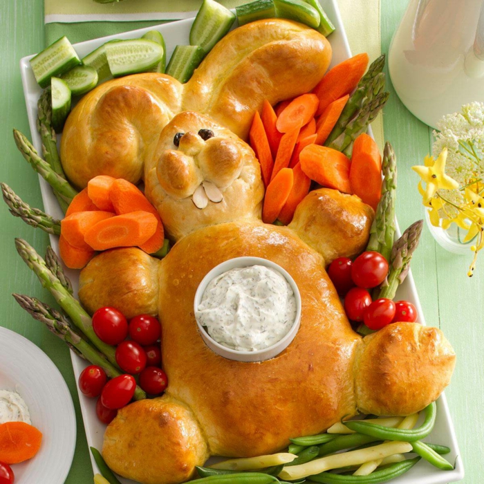 bread baked in the shape of a bunny, vegetables around it, easter dinner recipes, bowl of dip on top