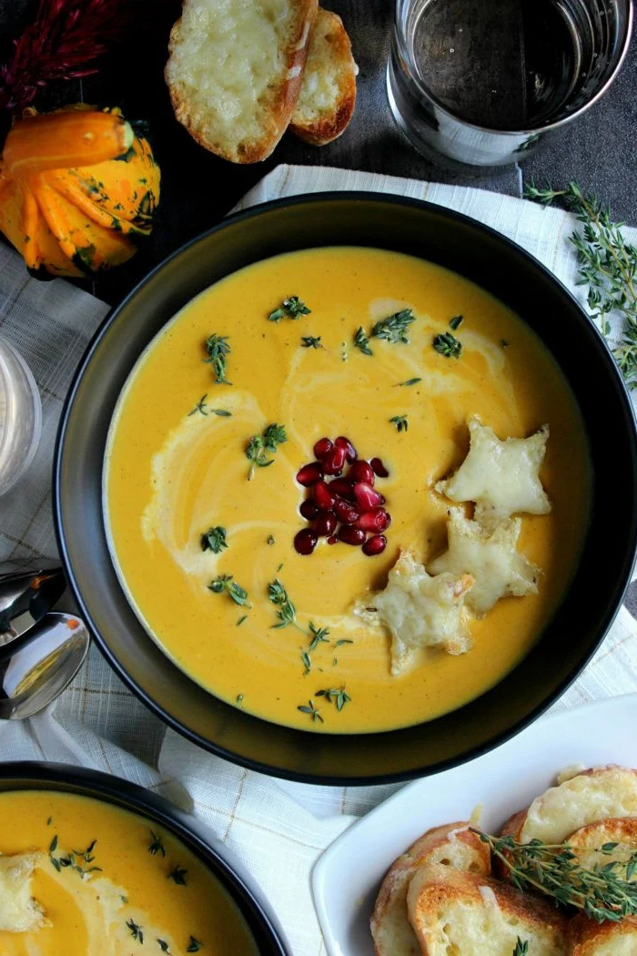 butternut squash soup, garnished with pomegranate seeds, dinner ideas for tonight, poured in black bowl