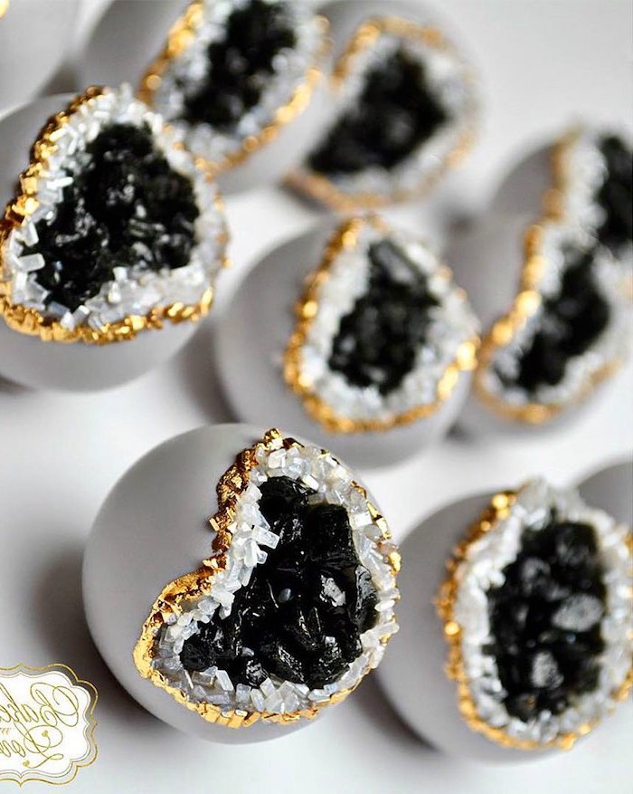 cake pops covered with grey fondant, geode wedding cake, decorated with black white and gold rock candy