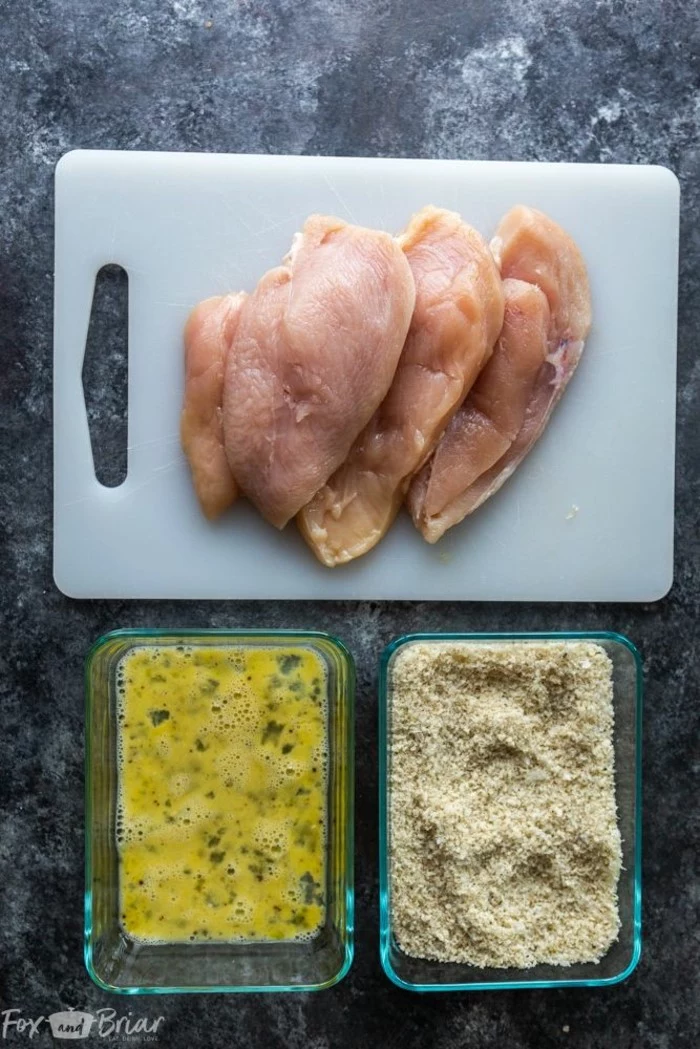 chicken breasts on white cutting board, eggs and breadcrumbs in glass bowls, easy dinner recipes for two, chicken parmesan recipe