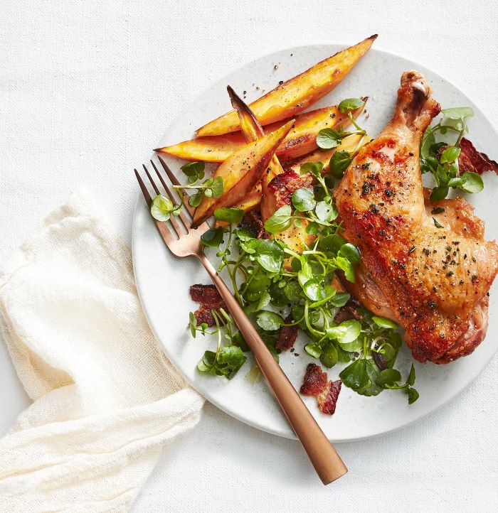 chicken thigh with green herbs, sweet potato wedges on the side, fork on the side of the plate, easy dinner recipes for beginners