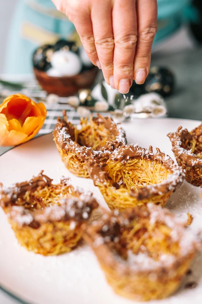 bird nests made of angel hair pasta, dipped in melted chocolate, sprinkled with coconut flakes, easter desserts