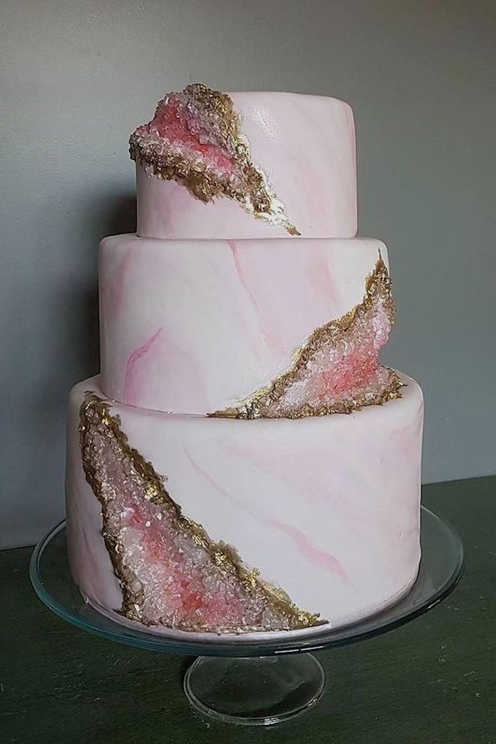 three tier cake, covered with pink and white marble fondant, decorated with pink and gold rock candy, geode wedding cake