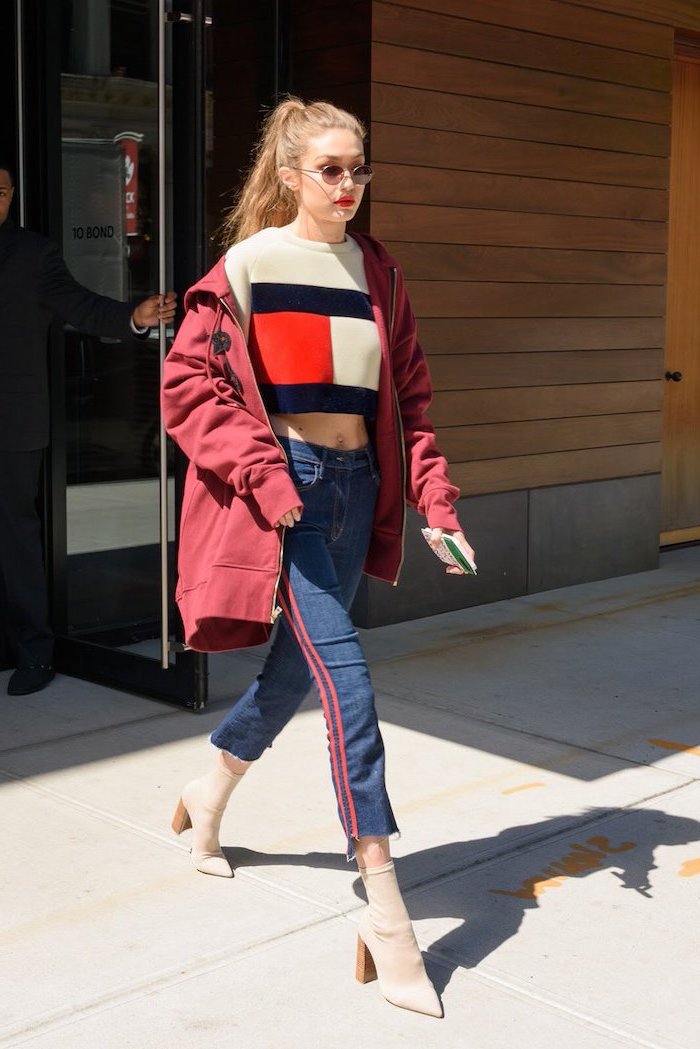 gigi hadid walking on a sidewalk, back to school outfits, wearing jeans and red hoodie, tommy hilfiger sweater