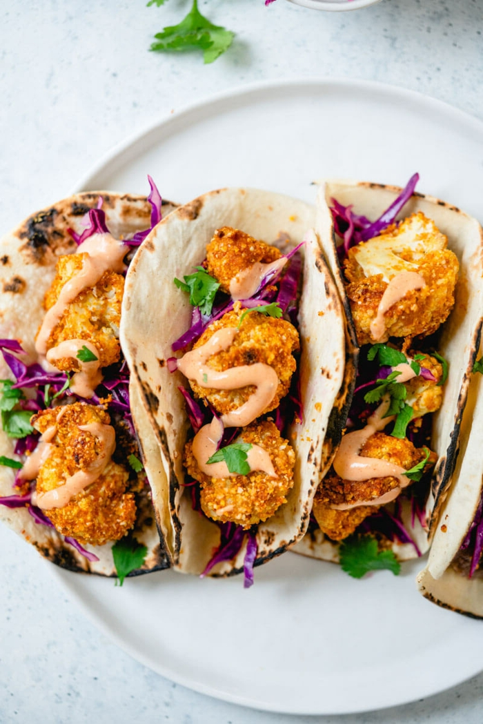 good home cooked meals, tacos with cauliflower balls, cabbage and parsley, creamy sauce on top