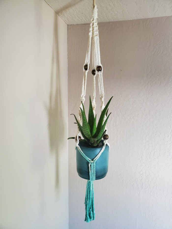 white and blue macrame, how to make a hanging planter, blue ceramic pot hanging from the ceiling, white wall in the background