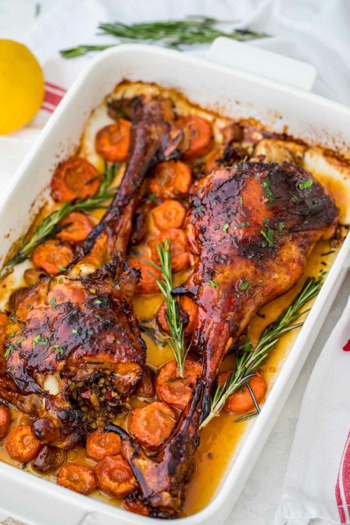 baked lamb with carrots, rosemary branches for garnish, easter buffet menu, baked in white casserole dish