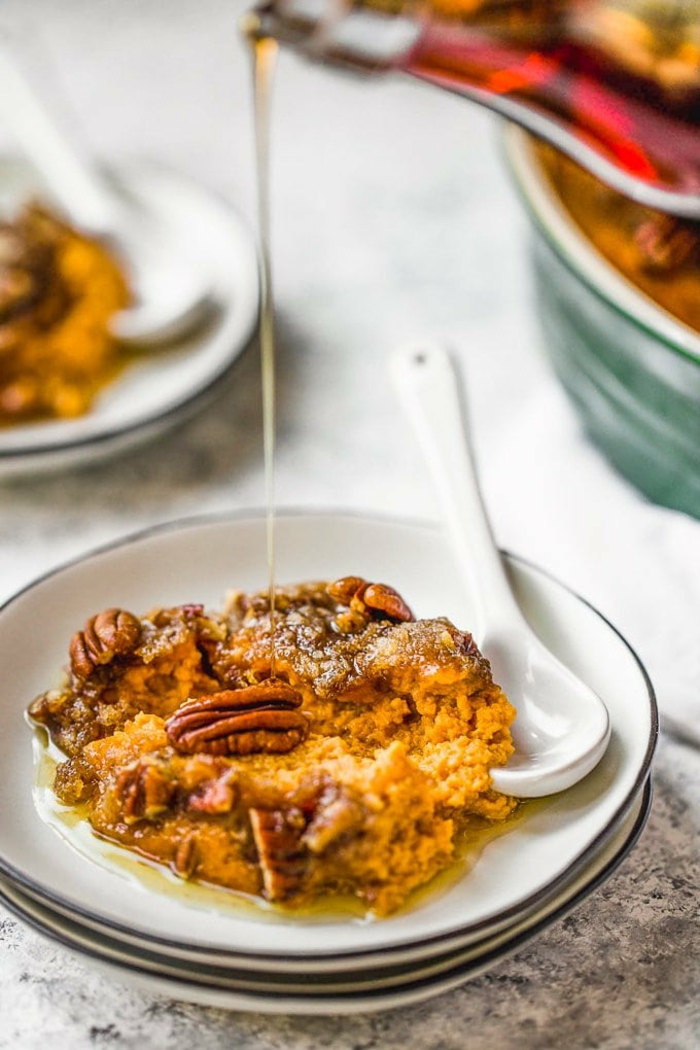 sweet potato casserole with pecans on top, easter dishes, piece of it placed on small white plate, white spoon on the side