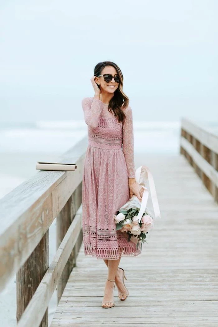woman with brown wavy hair, wearing a blush pink lace dress, easter outfits women, holding a bouquet of roses