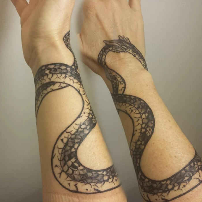 forearm tattoo of a serpent wrapped around the whole forearm, snake eating its tail, white background
