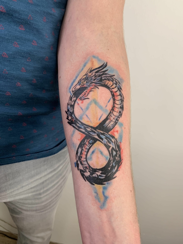 watercolor forearm tattoo, man wearing white jeans and blue shirt, ouroboros meaning, dragon as an infinity symbol