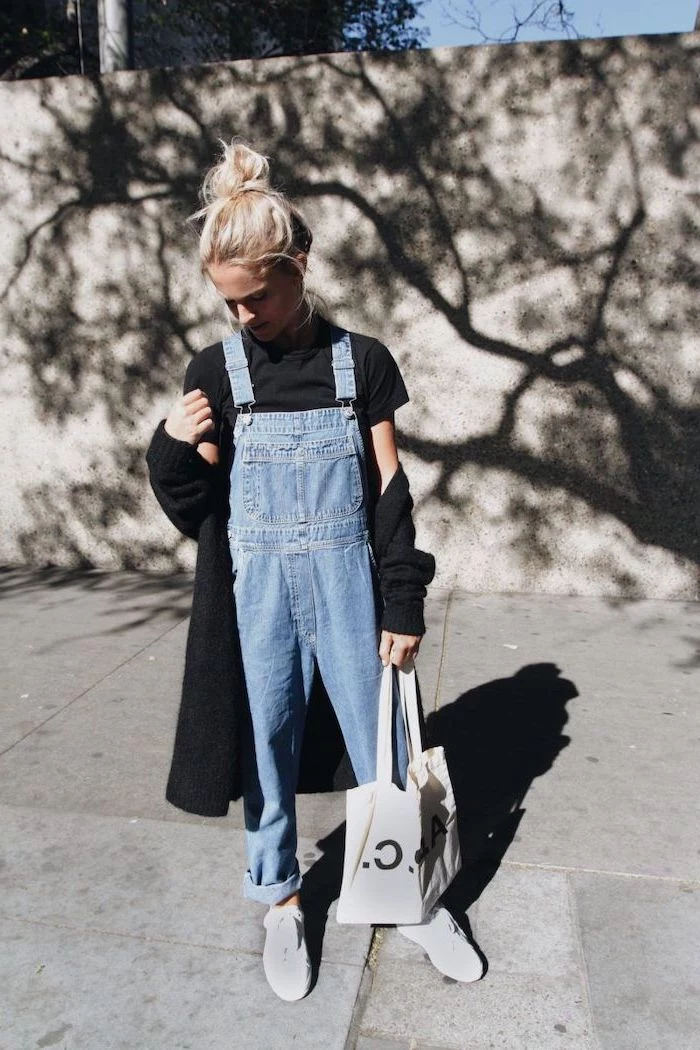 blonde girl wearing denim overalls, black shirt and cardigan, fall outfits for girls, white sneakers