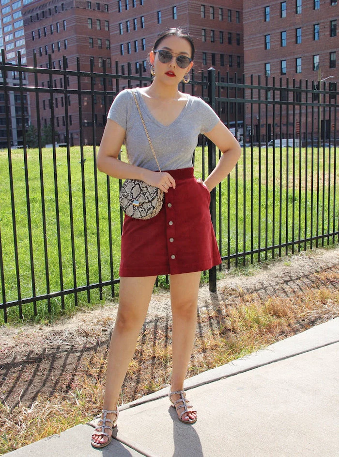 woman wearing red skirt, grey t shirt, snake skin bag and sandals, cute outfits for kids, standing on a sidewalk