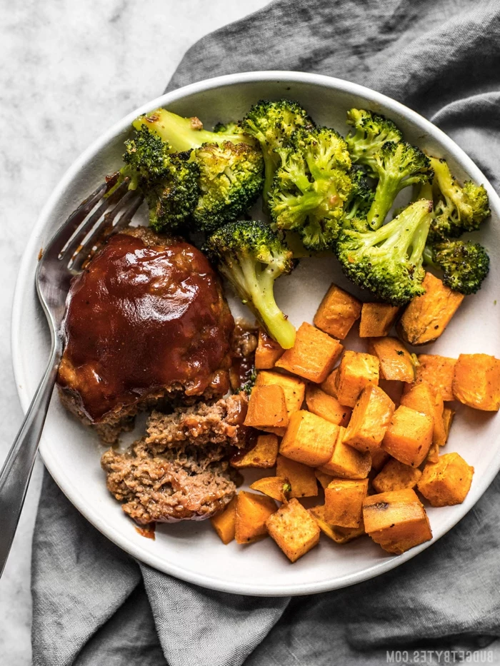 stealk with broccoli and sweet potatoes, quick and easy dinner recipes, placed on white plate with fork on the side