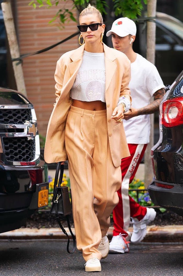 hailey bieber and justin bieber, first day of school outfits, wearing beige suit with white crop top, white sneakers