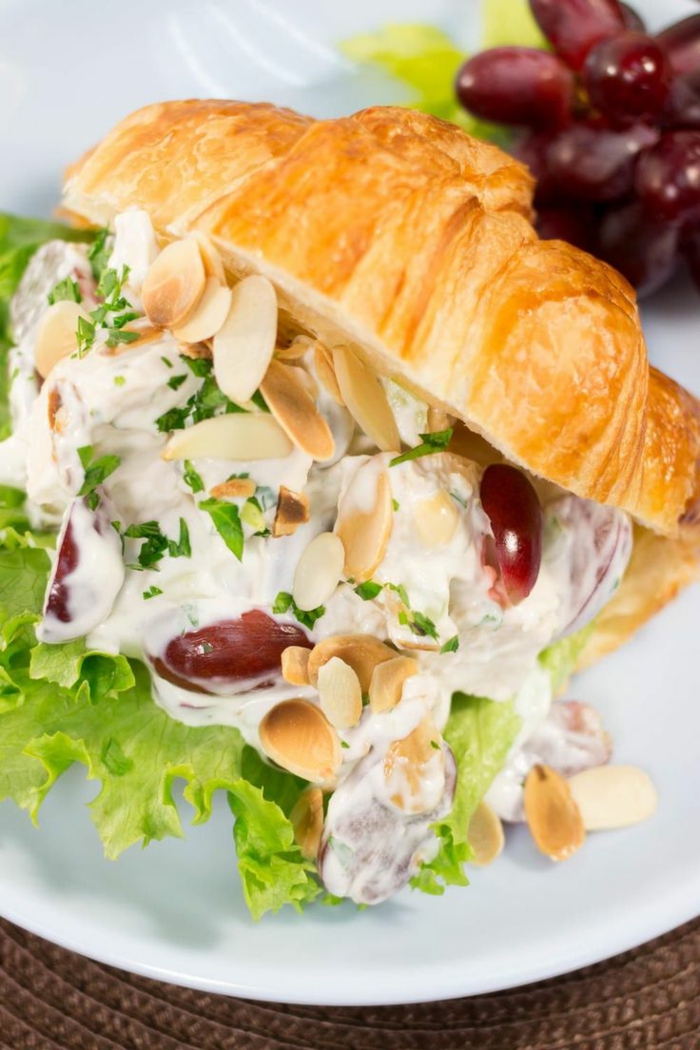 halved croissant, filled with lettuce and grapes, almonds and sauce inside, easter menu ideas 2019, placed on white plate