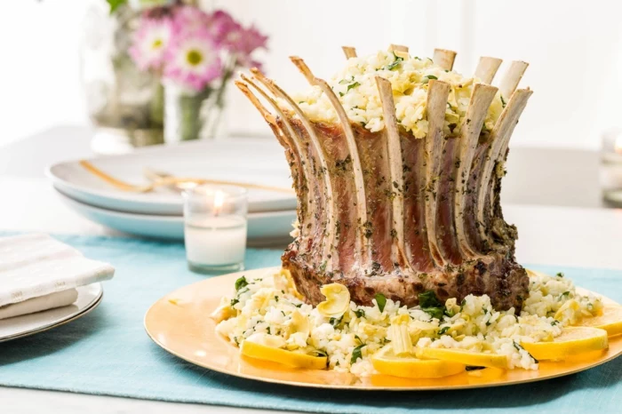 lamb ribs arranged on white plate, rice and lemon slices on the side, easter menu ideas 2019, placed on blue table cloth