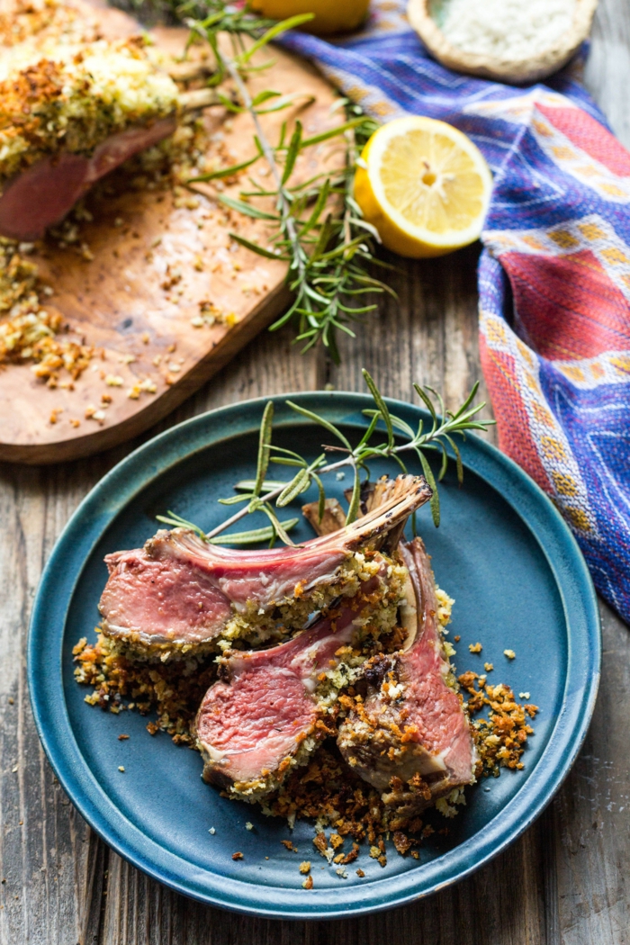 quick and easy dinner recipes, lamb with crust, placed on blue plate on wooden table, garnished with rosemary