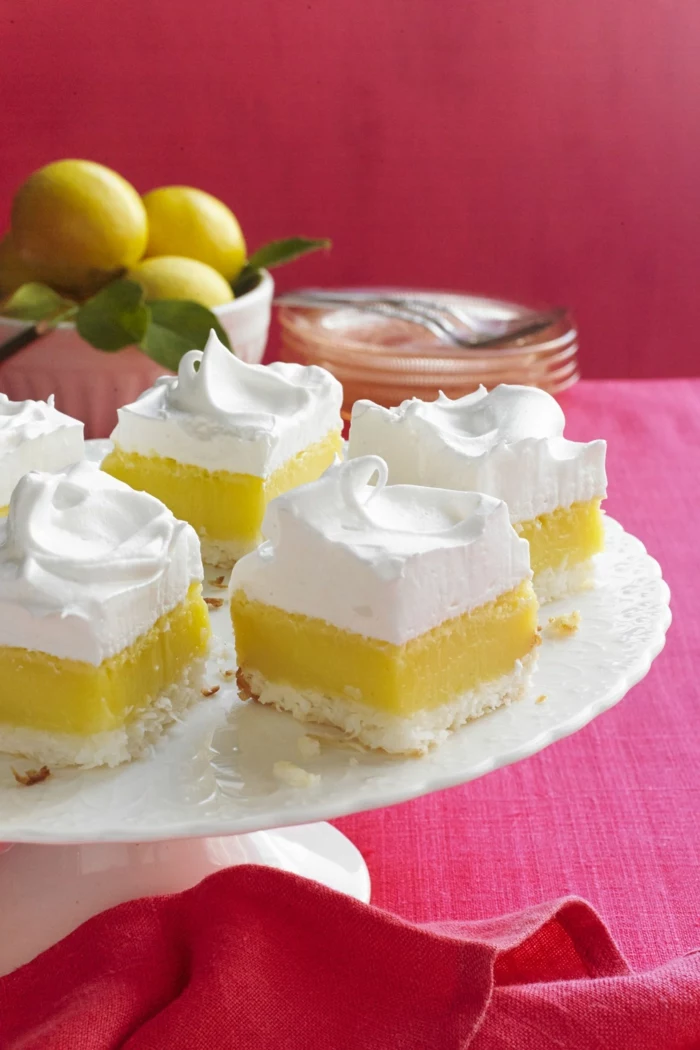 lemon pie cut into pieces, arranged on white cake stand, traditional easter food, red table cloth