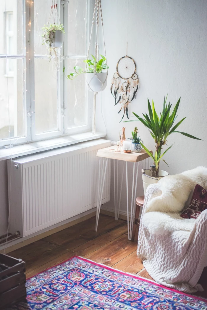 living room with wooden floor and white walls, plants hanging from the ceiling, macrame plant hanger diy, small armchair on the side