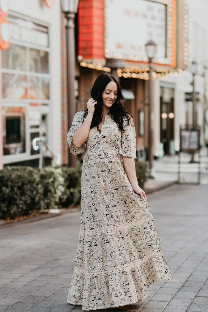 woman with black hair, wearing a long white dress with floral print, standing on a paved sidewalk, easter dresses 2019