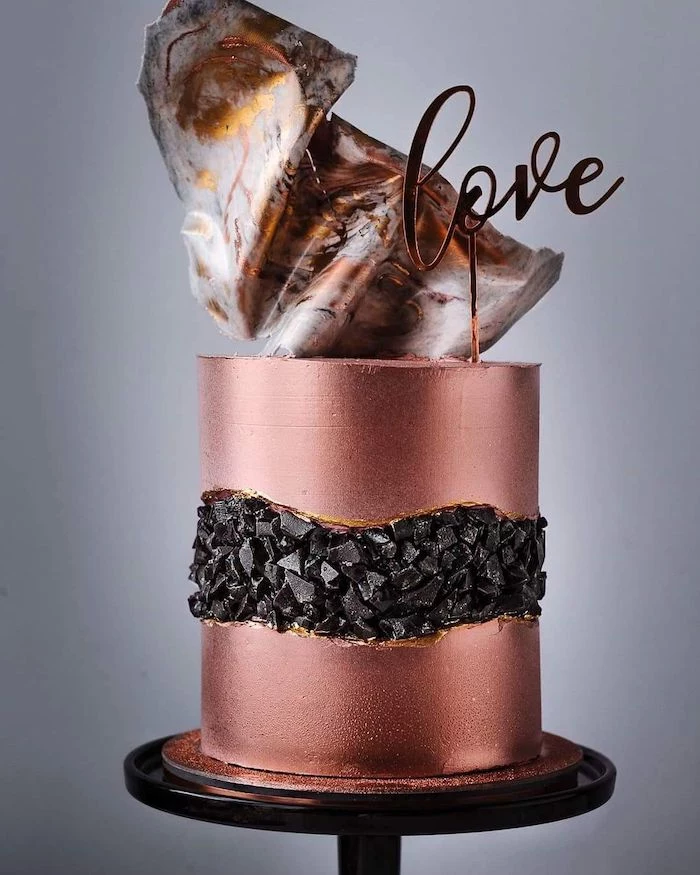 one tier cake, covered with rose gold fondant, geode cake recipe, decorated with black rock candy in the middle