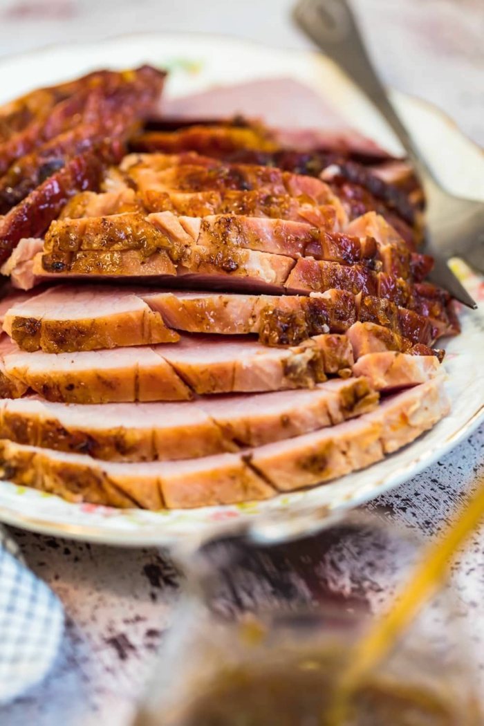 slices of ham, arranged on white plate, easter meal ideas, baked ham with marmalade glaze, fork on the side