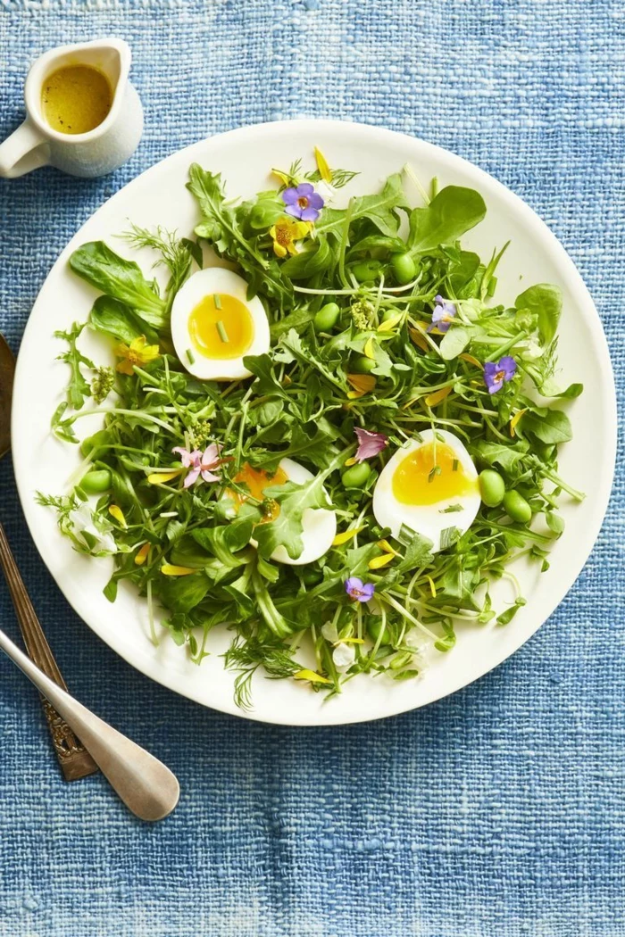 mixed green herb toss salad, halved boiled egg on top, placed in white plate, easter dinner ideas 2019, blue table cloth