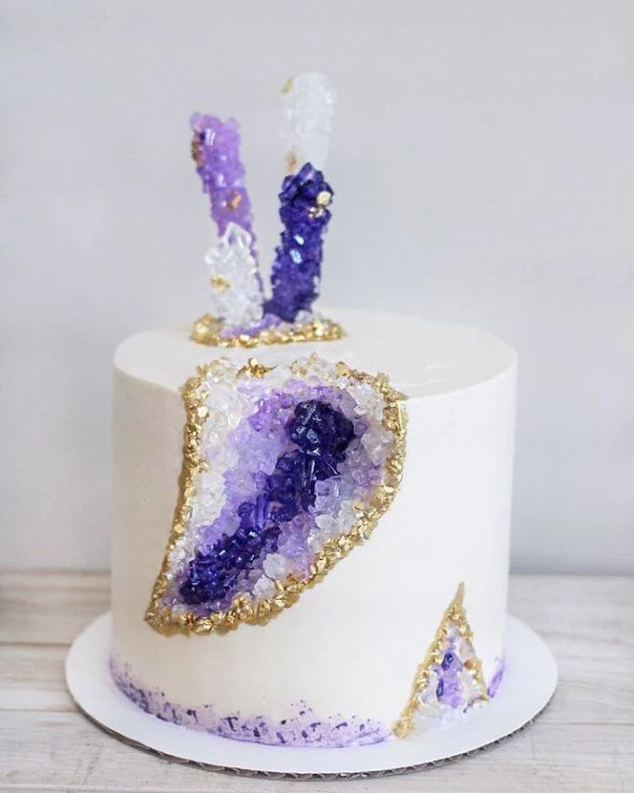 one tier cake, covered with white fondant, marble geode cake, decorated with white and purple rock candy
