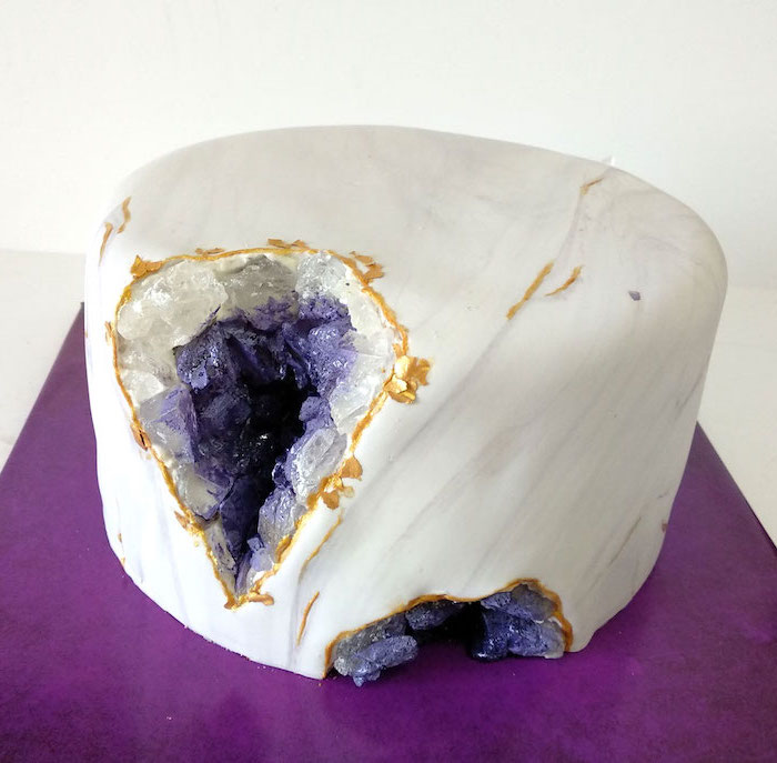 one tier cake, covered with white and grey marble fondant, decorated with white and purple rock candy, marble geode cake