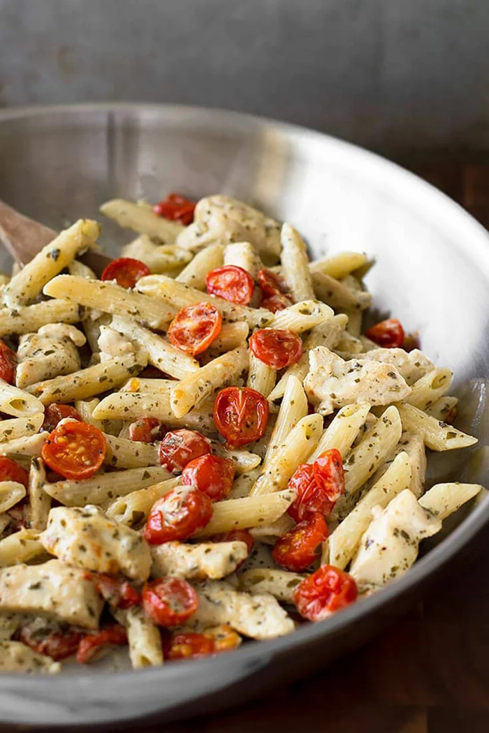 pesto chicken pasta, garnished with halved cherry tomatoes, easy dinners for two, cooked in metal sauce pan