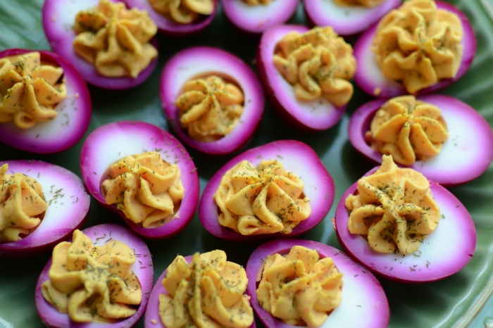 easter dinner ideas no ham, pickled eggs, garnished with dill, arranged on turquoise plate