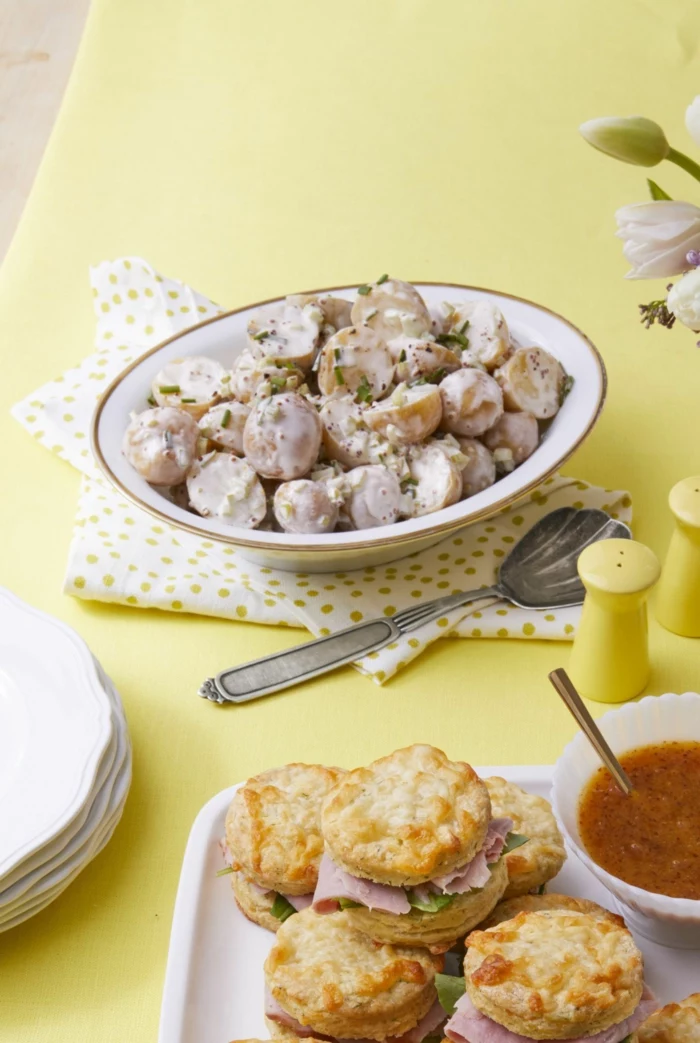 potato salad with creamy sauce in white bowl, easter dinner ideas no ham, small sandwiches with ham on the side
