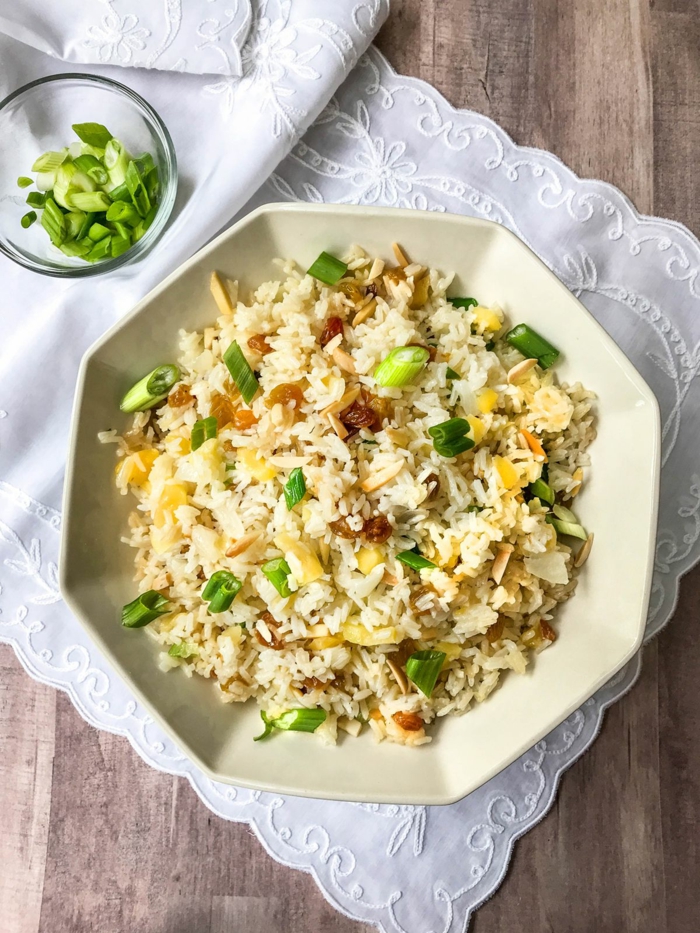 traditional easter dinner, rice pilaf in white hexagonal plate, placed on white table runner on wooden table