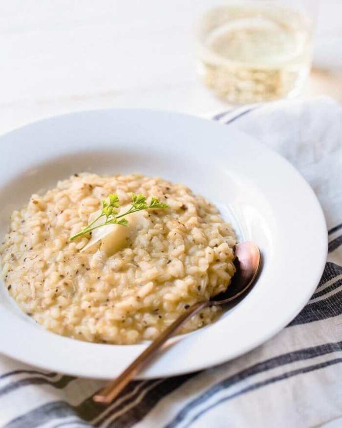 risotto with creame sauce, placed in white plate, easy dinner ideas for two, brass spoon on the side