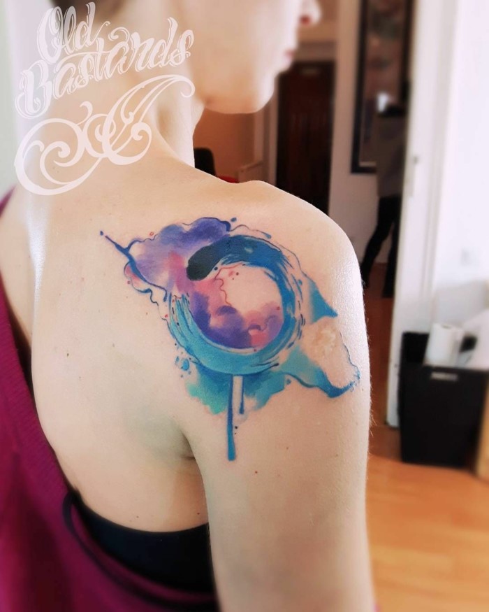 watercolor shoulder tattoo, ouroboros dragon, blue purple and pink colors, woman wearing purple sweatshirt