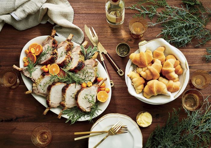 wooden table, easter buffet 2019, sliced lamb ribs in one plate, bread in a plate next to it