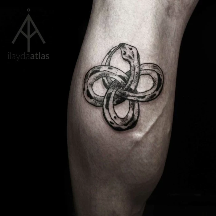 what does ouroboros mean, snake as a celtic symbol, back of leg tattoo, black background
