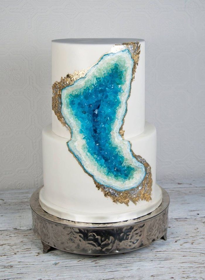 two tier cake, covered with white fondant, geode birthday cake, decorated with white and turquoise rock candy
