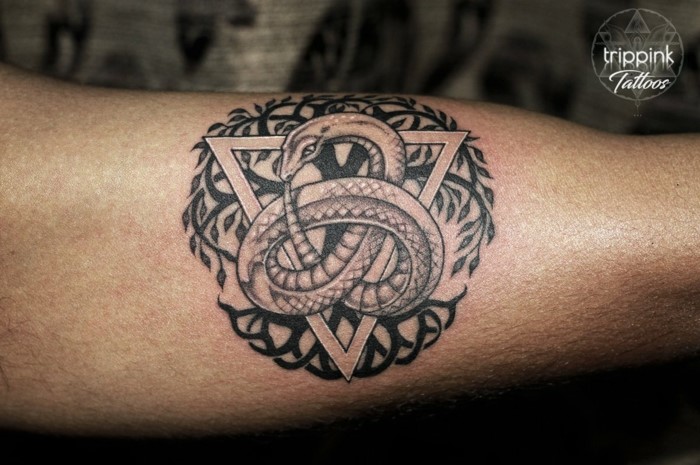 snake as a celtic symbol inside a triangle, tree of life in the back, serpent eating its own tail, inside arm tattoo
